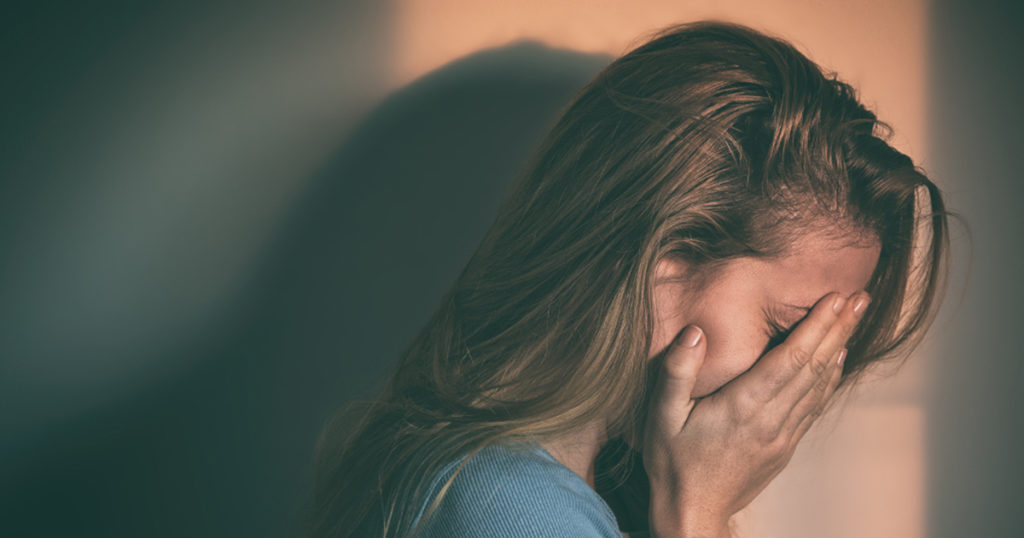 upset girl with face between her hands