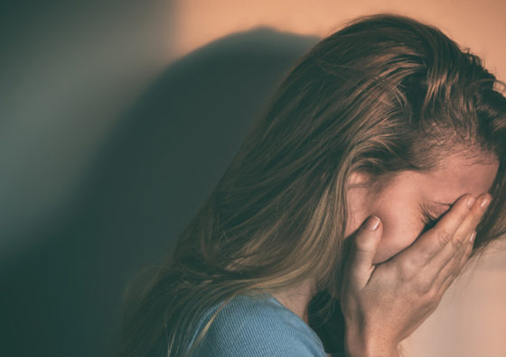upset girl with face between her hands