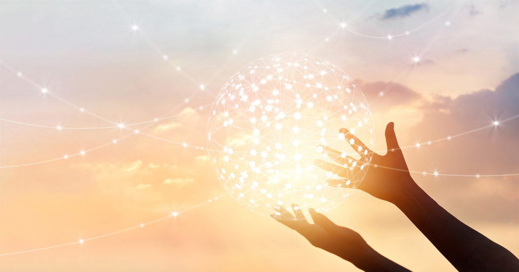 hands holding a glowing ball of connected dots