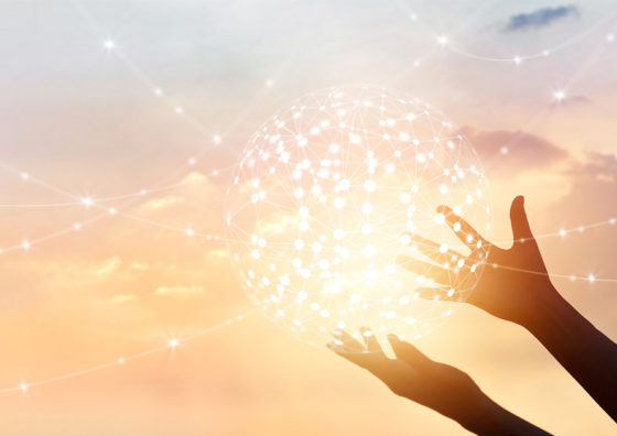 hands holding a glowing ball of connected dots