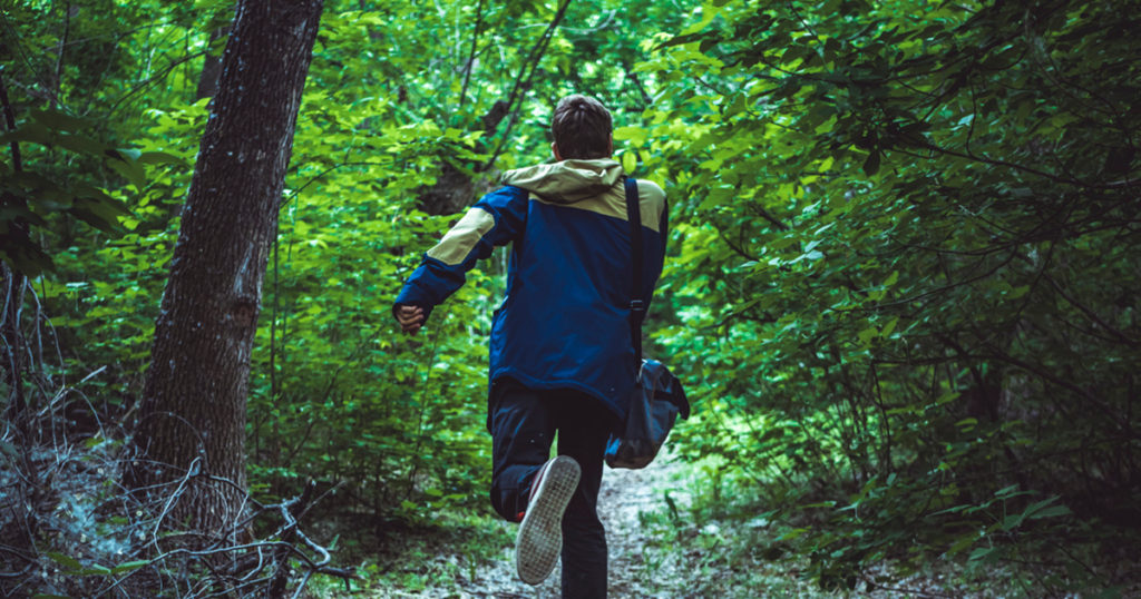 boy running in woods