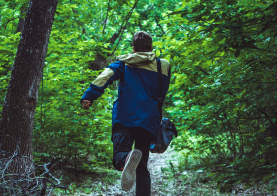 boy running in woods