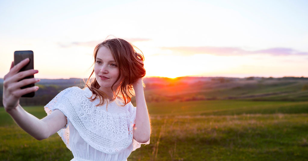 woman taking selfie in field