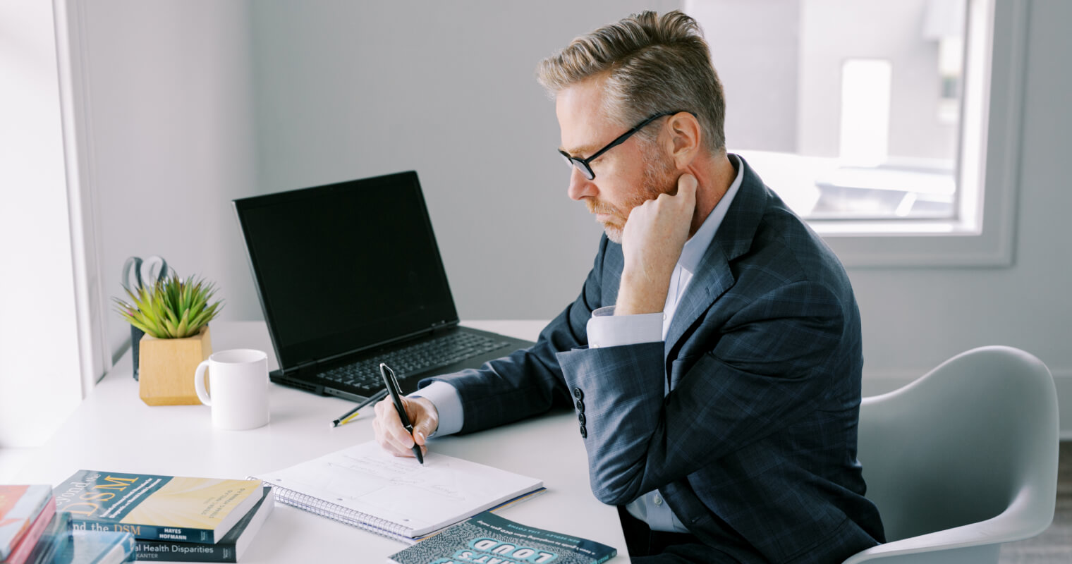 Matt Boone writing at a desk